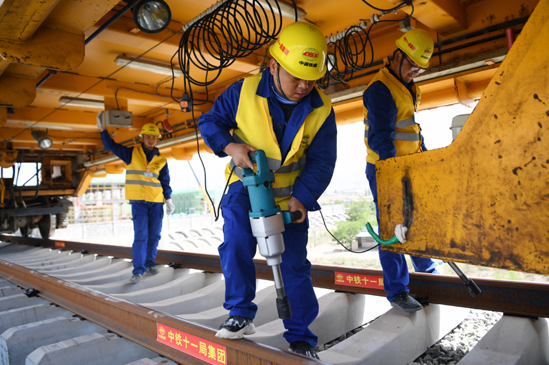 中蘭客專甘肅段線路全長173公里，設計時速250公里，是我國“八縱八橫”鐵路網京蘭通道的重要組成部分，計劃于2022年建成通車。圖為5月30日，中鐵十一局建設者在中蘭客專甘肅段鋪軌施工現場作業。（新華社記者 陳斌 攝）