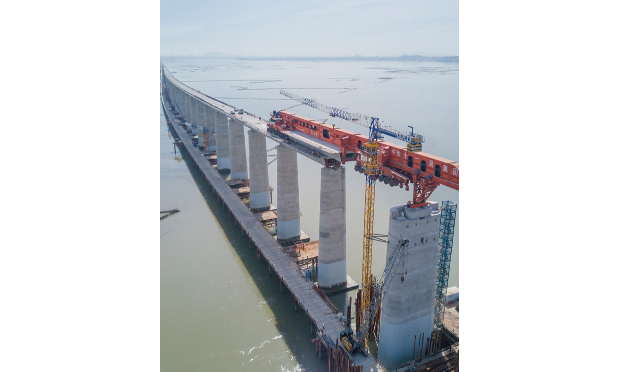 7月11日，我國自主研發(fā)的“昆侖號”千噸級運架一體機(jī)在中鐵十一局承建的新建福廈鐵路湄洲灣跨海大橋建設(shè)現(xiàn)場，圓滿完成最后一孔40米高鐵箱梁架梁任務(wù)。接下來，在經(jīng)過拆解、運輸、組裝之后，這臺體現(xiàn)我國高鐵橋梁架設(shè)最先進(jìn)技術(shù)的大國重器將在浙江參與杭衢鐵路的建設(shè)。圖為在新建福廈鐵路湄洲灣跨海大橋建設(shè)現(xiàn)場，“昆侖號”在架設(shè)該線路最后一孔40米箱梁。（新華社記者 宋為偉 攝）