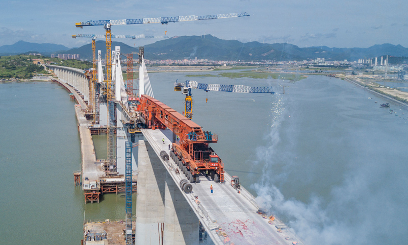 圖為7月11日，在新建福廈鐵路湄洲灣跨海大橋建設(shè)現(xiàn)場，“昆侖號”千噸級運架一體機(jī)完成架梁任務(wù)后的慶祝場面。（新華社記者 宋為偉 攝）