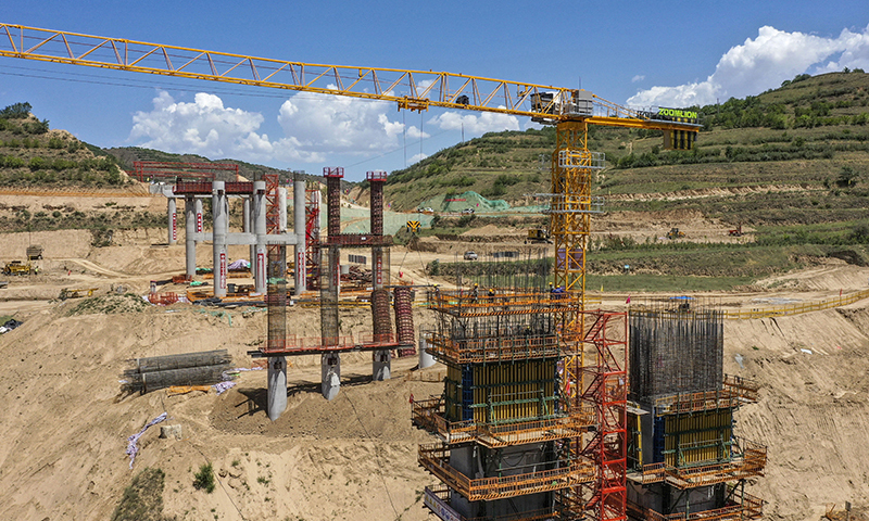 近日，在銀（川）昆（明）高速寧夏境內的LJ12-1標段，來自中鐵二十一局的建設者們正在加緊施工。銀昆高速寧夏段項目起于吳忠市太陽山開發區，經過吳忠市利通區、紅寺堡區、同心縣，中衛市海原縣等，止于固原市彭陽縣的寧夏與甘肅交界處，全長237公里。圖為建設工人在銀昆高速寧夏境內的LJ12-1標段的虎岔大橋上施工作業（無人機照片）。新華社記者 馮開華 攝