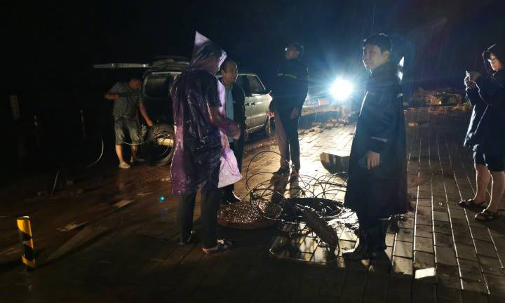 中國聯通工作人員冒雨搶修故障，暴風驟雨中誓保通信安全。