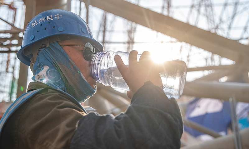 圖為中建八局施工人員在重慶龍興足球場施工間隙補(bǔ)充水分。新華社記者 黃偉 攝