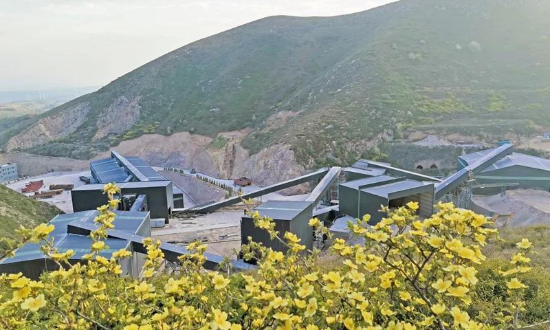 圖為葛洲壩路橋公司山西平陸砂石項(xiàng)目部堅(jiān)持“邊開采邊治理”的原則，及時對礦山進(jìn)行恢復(fù)治理，綠化植樹面積近4500平方米；骨料生產(chǎn)采用工廠化生產(chǎn)模式，全方位配備除塵器和噴淋系統(tǒng)。