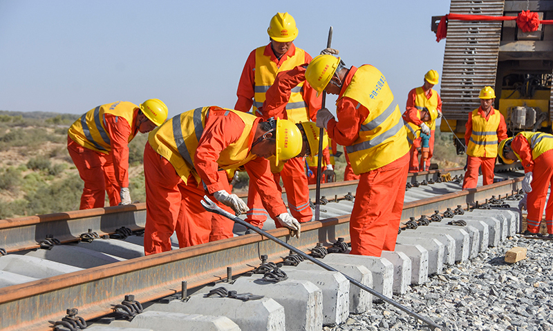 圖為鋪軌完成后工人們進行后續(xù)施工。（新華社記者 陶方偉 攝）