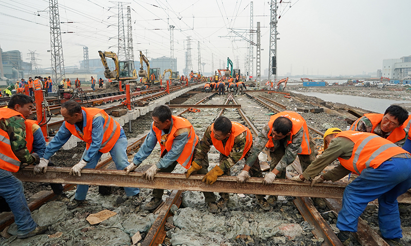 圖為工人在施工現場搬運鐵軌。（新華社記者 牟宇 攝）