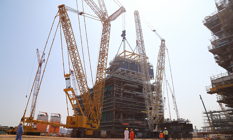 在中國(guó)海油海油工程建造事業(yè)部青島場(chǎng)地加拿大LNG項(xiàng)目模塊總裝區(qū)，經(jīng)過(guò)施工人員多天連續(xù)奮戰(zhàn)，加拿大LNG項(xiàng)目第二個(gè)Mini E-House（電氣間）精準(zhǔn)就位于A1EB模塊指定位置。圖為Mini E-House（電氣間）吊裝現(xiàn)場(chǎng)。