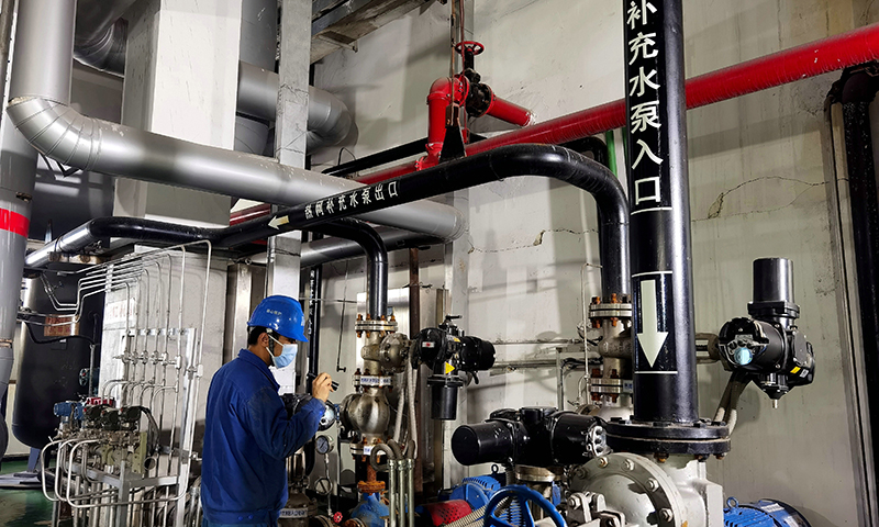 圖為華能鶴崗電廠檢修部員工在供熱首站巡視設備運行情況。