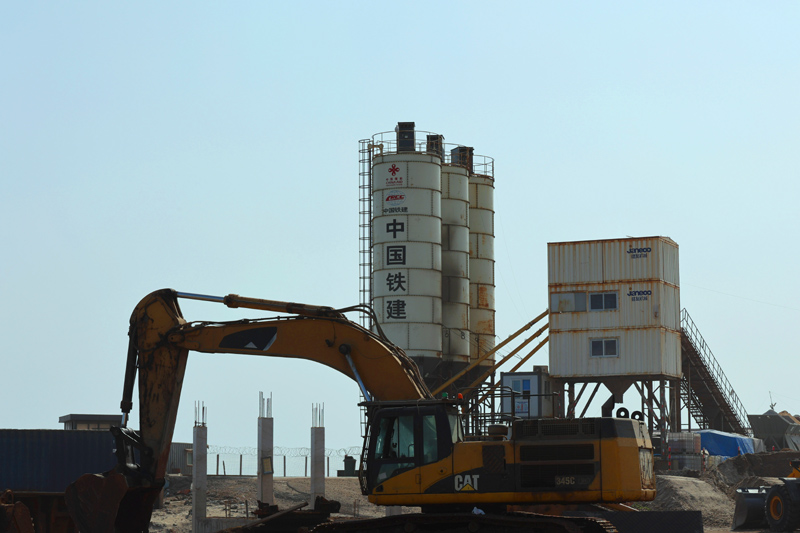 該項目2020年8月開工，預(yù)計2023年2月完工，建成后將極大改善當?shù)貪O民的工作和生活環(huán)境。圖為在加納首都阿克拉，挖掘機在中國援建加納漁港綜合設(shè)施項目施工現(xiàn)場作業(yè)。（新華社記者 許正 攝）