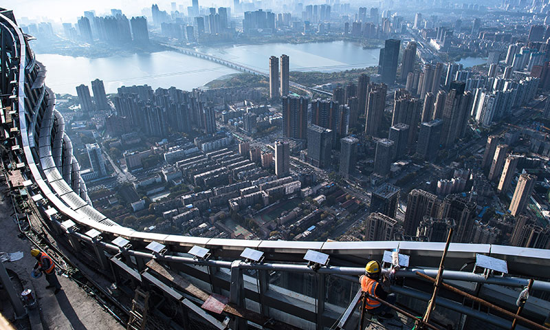 在武漢綠地中心項目建設現場近500米高的“云端”，近百名中建三局二公司的工人，伴著腳下的長江波濤，穩步推進工程建設，仿佛演奏著“交響曲”。圖為11月15日，中建三局二公司工人在武漢綠地中心項目建設現場近500米的高空施工。（新華社記者 肖藝九 攝）