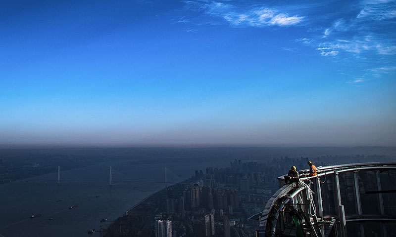 武漢綠地中心項目目前進入收尾階段，預計將按原計劃完成建設任務。圖為11月15日，中建三局二公司工人在武漢綠地中心項目建設現場近500米的高空施工。（新華社記者 肖藝九 攝）