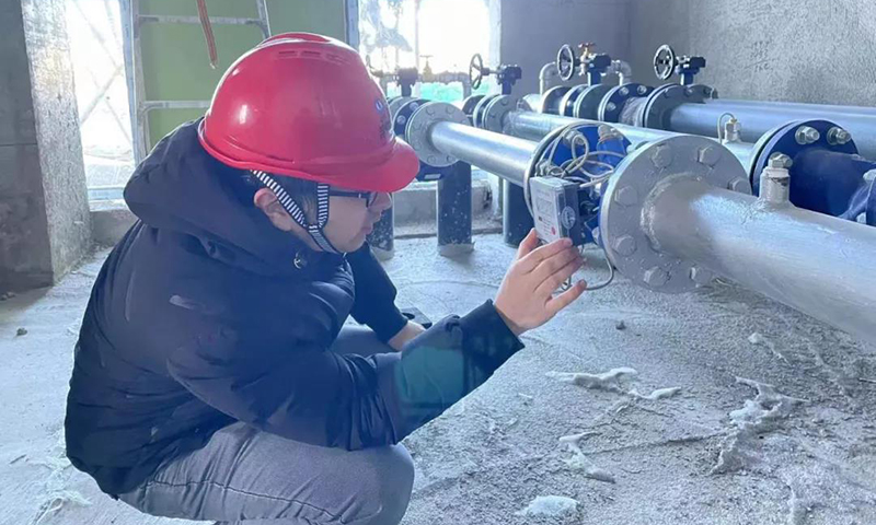 圖為在烏蘭察布源網(wǎng)荷儲(chǔ)項(xiàng)目現(xiàn)場(chǎng)，室外大雪紛飛，設(shè)計(jì)師正全程跟蹤三峽現(xiàn)代能源創(chuàng)新示范園供熱調(diào)試。 （ 攝影：肖志斌）