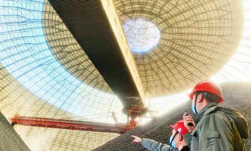 國家能源集團(tuán)國神公司煤礦單位職工現(xiàn)場指揮堆煤機(jī)落煤，全力保障供應(yīng)。