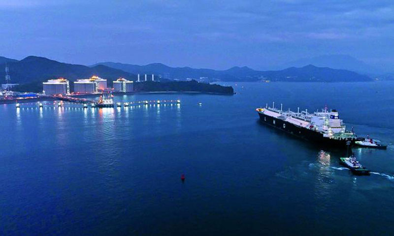 圖為我國自主建造的首艘LNG船舶“大鵬號”迎著晚霞緩緩駛向大鵬LNG接收站碼頭，拉開首次夜間靠泊作業(yè)序幕。