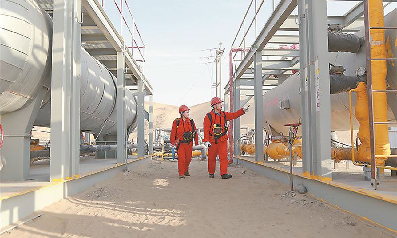 1月1日一大早，塔里木油田塔中油氣開發部第二采油氣作業區采油班班長楊鵬生來到中古162-H1井，開始巡井工作。圖為楊鵬生和安海燕在巡井。