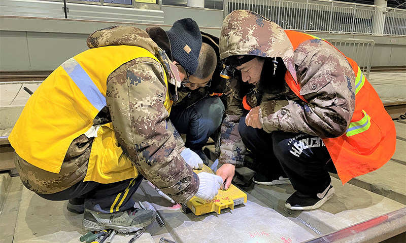 圖為中鐵六局電務(wù)公司建設(shè)者安裝應(yīng)答器。