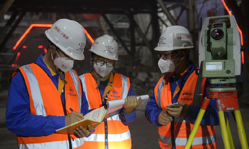 正在施工的九萬大山4號隧道全長15.5公里，是貴南高鐵廣西段最長的隧道，地質情況復雜，開挖難度極大,截止目前，該隧道已完成開挖13867米，剩余1598米，面對復雜的地質條件，該項目每天以25米的開挖速度向前掘進。圖為技術人員正在核實測量數據。