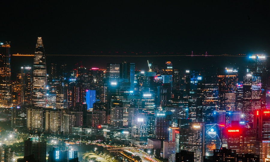 在燈火璀璨的深圳南山中心區(qū)，遠眺可見港珠澳大橋。