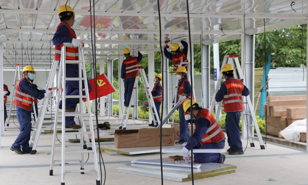 中鐵電氣化局海南維管段接到地方政府通知后第一時(shí)間成立援建小組，先后投入130余人次參與防疫設(shè)施建設(shè)。于8月15日完成儋州方艙醫(yī)院四號(hào)艙4層AB區(qū)512組插座測(cè)量排查和修理更換，8月17日完成樂東隔離病房40套立柱、頂棚及80套照明燈具等任務(wù)。圖為中鐵電氣化局參與樂東隔離病房建設(shè)。