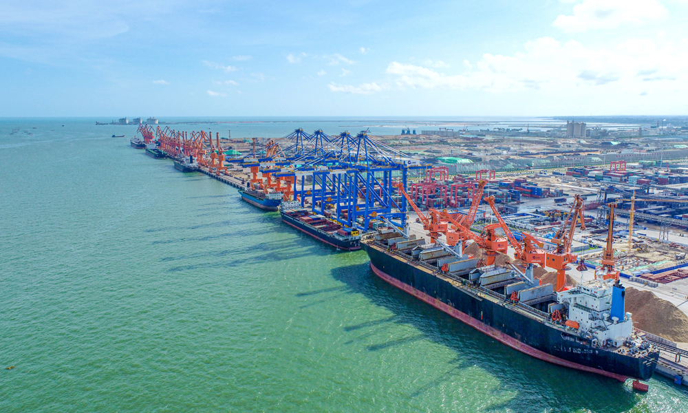 近日，北部灣港輪船進(jìn)進(jìn)出出，運(yùn)輸車輛絡(luò)繹不絕，碼頭生產(chǎn)作業(yè)一派繁忙景象。門式抓斗起重機(jī)巨大的抓斗將銅精礦從滿載的船舶上卸下，由集裝箱卡車運(yùn)至火車，一列列裝滿貨物的班列從碼頭奔向全國(guó)各地。