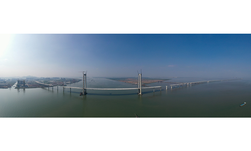 10月8日，隨著第155片60米混凝土箱梁在廣東中山智慧梁場(chǎng)完成預(yù)制，由中鐵大橋局承建的深中通道全線(xiàn)非通航孔橋共791片混凝土箱梁預(yù)制工作全部完成。深中通道是集“橋、島、隧、水下互通”于一體的超大型跨海集群工程，全長(zhǎng)約24公里，其中橋梁工程長(zhǎng)約17公里。圖為建設(shè)中的深中通道中山大橋。新華社記者 劉大偉 攝