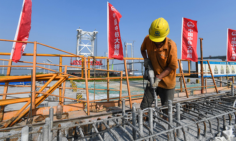 10月8日，施工人員在中山智慧梁場(chǎng)的第155片60米混凝土箱梁上進(jìn)行鑿毛作業(yè)。新華社記者 劉大偉 攝