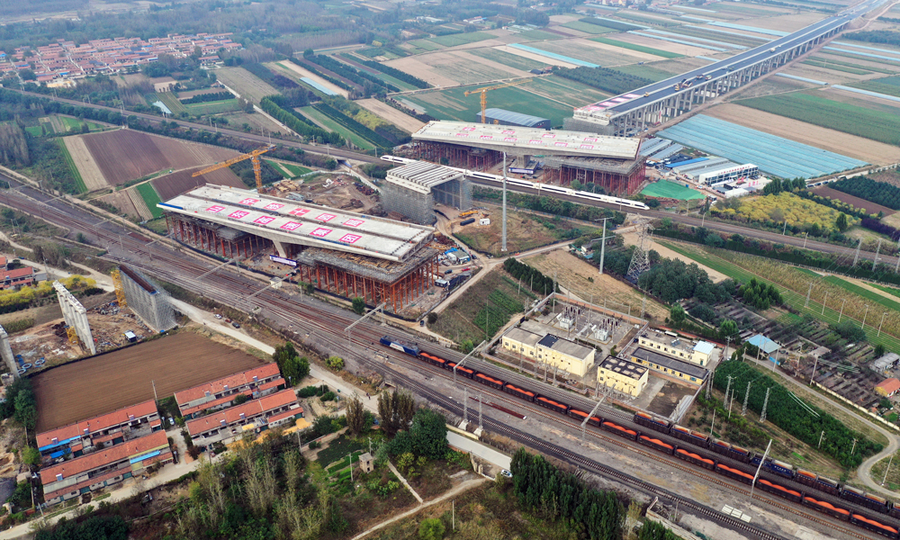 作為濰青高速的關(guān)鍵控制性工程，上跨橋分別與膠濟(jì)客專和膠濟(jì)鐵路2條線路連續(xù)交叉，采用T型剛構(gòu)連續(xù)梁轉(zhuǎn)體施工，是國(guó)內(nèi)目前總噸位最重、橋面最寬的高速公路跨鐵路連續(xù)T型剛構(gòu)轉(zhuǎn)體橋。該工程主梁線形控制、技術(shù)精度要求極高，緊鄰膠濟(jì)客運(yùn)專線和膠濟(jì)鐵路等繁忙干線，每天通過(guò)列車(chē)多達(dá)305趟。在轉(zhuǎn)體過(guò)程中，建設(shè)團(tuán)隊(duì)首次使用北斗導(dǎo)航定位系統(tǒng)對(duì)橋梁轉(zhuǎn)角及姿態(tài)監(jiān)控，實(shí)時(shí)采集數(shù)據(jù)，通過(guò)“全程可視化、控制智能化”提前分析告警，保障夜間施工安全可控。圖為鐵路列車(chē)經(jīng)過(guò)轉(zhuǎn)體前的大橋旁。