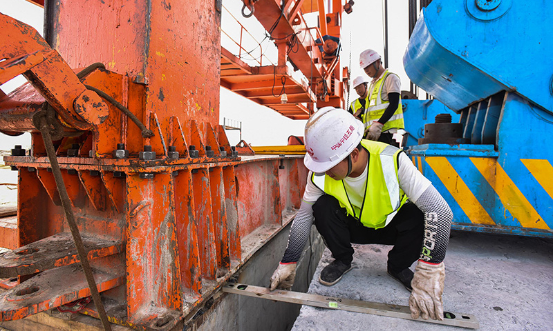 10月25日，施工人員在增江特大橋架梁現場輔助架橋機調整精度。新華社記者 劉大偉 攝
