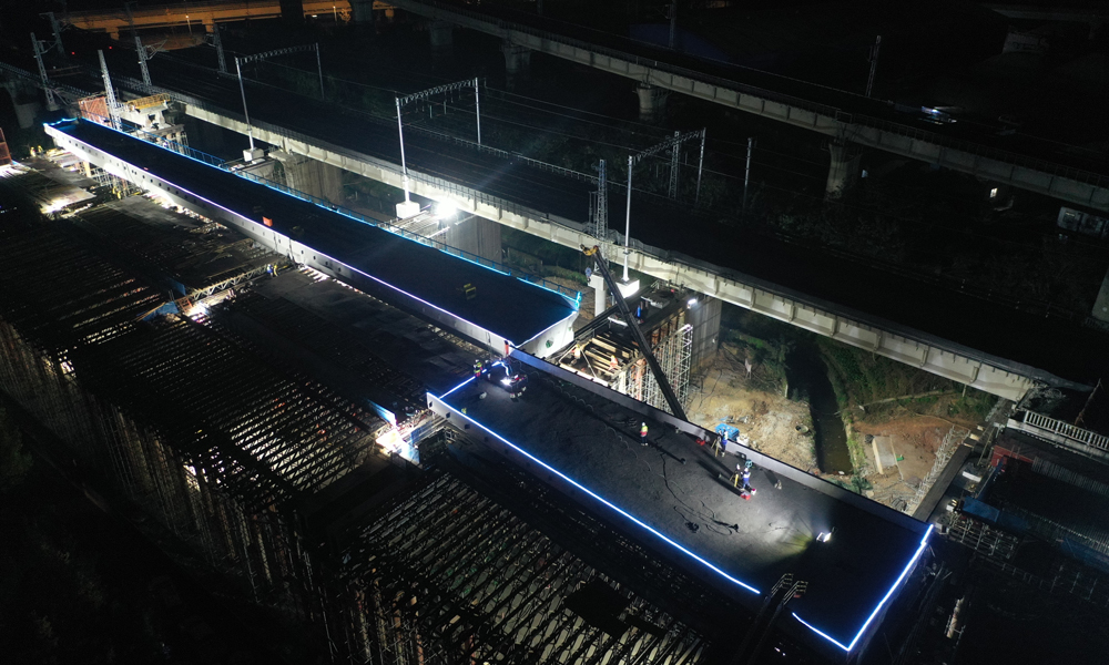 成自高鐵是國家“八橫八縱”高速鐵路網(wǎng)中“京昆通道”的重要組成部分，全長176公里，是四川省首條時速350公里的高速鐵路。建成后，對加快地區(qū)融入長江經(jīng)濟帶發(fā)展戰(zhàn)略，推進西部大開發(fā)進程，加快區(qū)域合作與發(fā)展具有重要意義。圖為夜間平移施工。