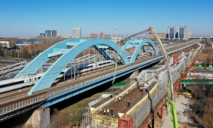 12月22日，濟(jì)（南）鄭（州）高鐵跨濟(jì)南經(jīng)十西路槽型梁順利合龍，為濟(jì)鄭高鐵后續(xù)架梁、鋪軌等工作奠定良好基礎(chǔ)。圖為中鐵十局的工作人員在對濟(jì)鄭高鐵跨濟(jì)南經(jīng)十西路槽型梁進(jìn)行合龍作業(yè)（無人機(jī)照片）。新華社記者 郭緒雷 攝