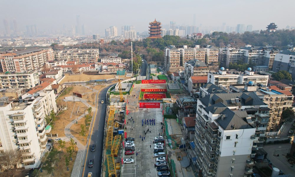 施工期間，建設(shè)者成立盾構(gòu)技術(shù)專家組，對盾構(gòu)機選型設(shè)計及施工難題進行指導(dǎo)把關(guān)。為保障盾構(gòu)機在硬巖中長距離掘進，他們?yōu)槎軜?gòu)機配備了鉆注一體式超前地質(zhì)鉆機和超前物探系統(tǒng)，并應(yīng)用自動化監(jiān)測施工技術(shù)，對沿線敏感建構(gòu)筑物布設(shè)觀測點，實時監(jiān)測沉降數(shù)據(jù)，同步調(diào)整掘進參數(shù)，實現(xiàn)了安全平穩(wěn)穿越。據(jù)了解，和平大道南延工程通車后，將有效改善武昌古城交通出行條件、緩解中山路-白沙洲大道交通壓力、形成武昌順江方向的交通骨干通道。圖為隧道下穿黃鶴樓景區(qū)。