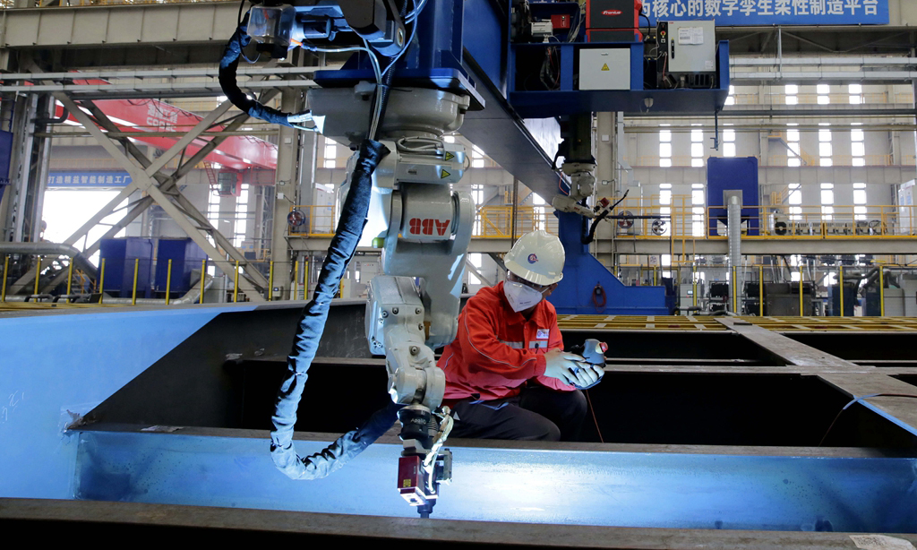 在預(yù)舾裝場地，有限天津分公司項(xiàng)目質(zhì)量工程師嘗到了“一體化”的甜頭：“一體化創(chuàng)造了各專業(yè)同步聯(lián)合檢驗(yàn)的條件，不僅有利于現(xiàn)場溝通，還能統(tǒng)籌梳理檢驗(yàn)進(jìn)度，倒推施工順序，提前釋放隱蔽工程。”據(jù)統(tǒng)計(jì)，聯(lián)合檢驗(yàn)降低了隱蔽工程的返工和交叉作業(yè)，油漆破損率降低70%，檢驗(yàn)效率提高30%。圖為工作人員操作機(jī)器人進(jìn)行焊接作業(yè)。