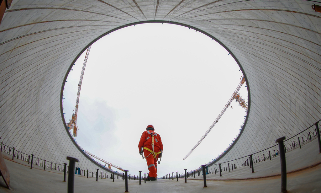 金灣“綠能港”位于廣東珠海金灣區(qū)高欄港，是珠江口西岸最大的液化天然氣接收站。走進(jìn)現(xiàn)場(chǎng)，5座高65.7米、直徑94.2米的LNG（液化天然氣）儲(chǔ)罐矗立在青山碧海間。二期項(xiàng)目同時(shí)建設(shè)5座27萬(wàn)立方米LNG儲(chǔ)罐及配套設(shè)施，已被列入國(guó)家石油天然氣基礎(chǔ)設(shè)施重點(diǎn)工程。圖為作業(yè)人員在穹頂進(jìn)行安全檢查。