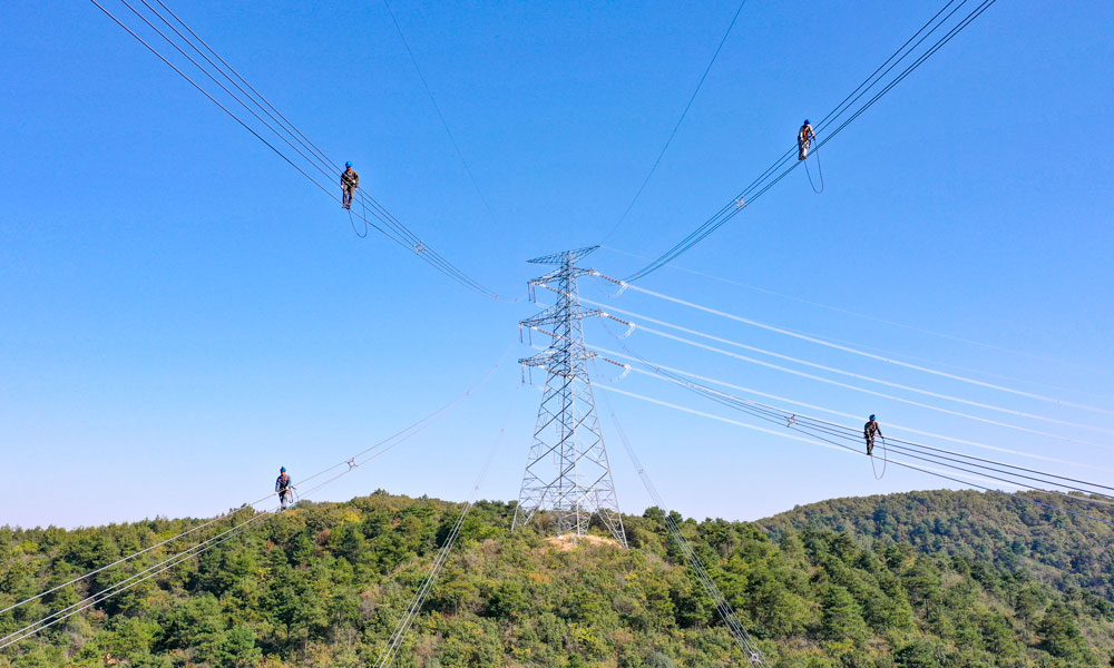 國家電網江蘇省送變電有限公司輸電人員在高空走線驗收消缺。