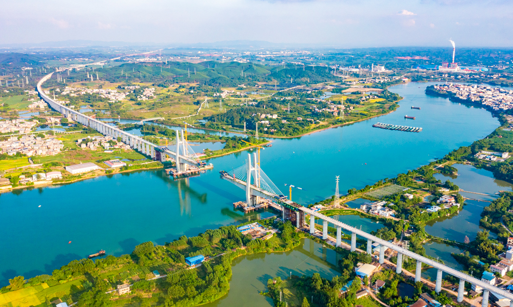 日前，中國鐵建所屬中鐵十一局承建的南深高鐵南玉段六景郁江特大橋首節(jié)鋼箱梁成功安裝，標(biāo)志著該特大橋正式開啟鋼箱梁施工，進(jìn)入合龍前沖刺階段。圖為建設(shè)中的六景郁江特大橋。