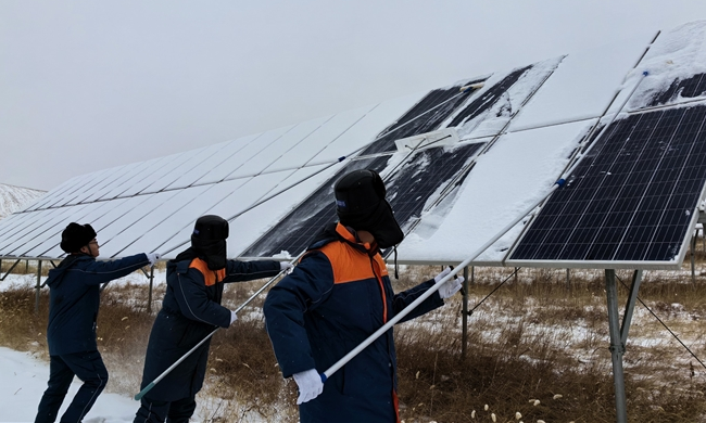 中廣核山西右玉風光互補電站作業(yè)人員清除電站周邊通道及光伏板上的積雪。