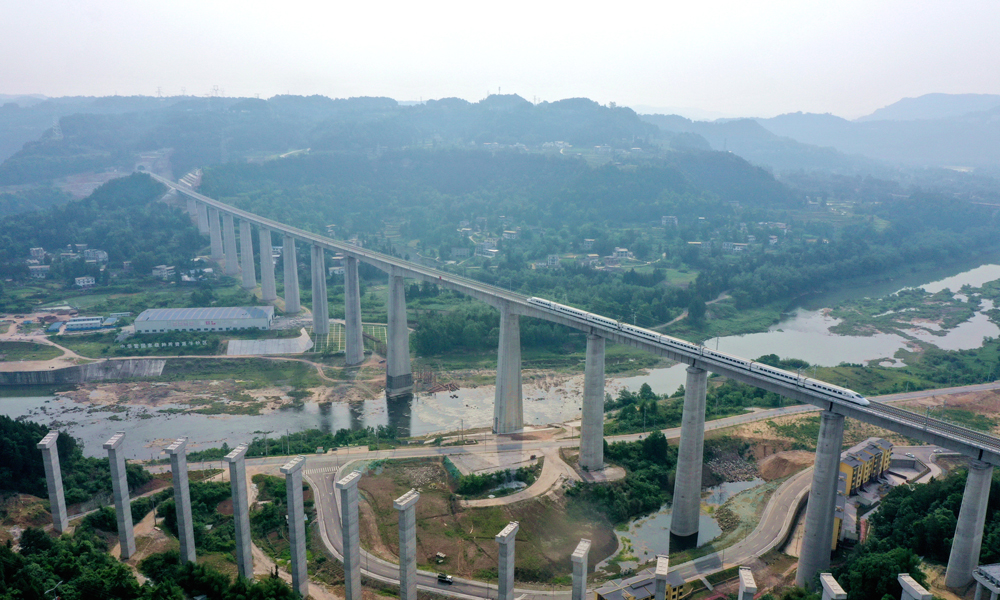 巴南高鐵位于四川省東北部，正線全長(zhǎng)148公里，設(shè)計(jì)時(shí)速250公里，于2019年底開工建設(shè)。其選線縱貫儀隴、巴中、南鄭等川陜革命根據(jù)地核心地帶，是追溯英雄足跡的“紅色高鐵”，更是一條飛躍天塹、打通阻隔，催動(dòng)區(qū)域發(fā)展勢(shì)能，落實(shí)鄉(xiāng)村振興戰(zhàn)略的“振興高鐵”。圖為列車通過巴南高鐵控制性工程、全線第一高橋——恩陽(yáng)河大橋。