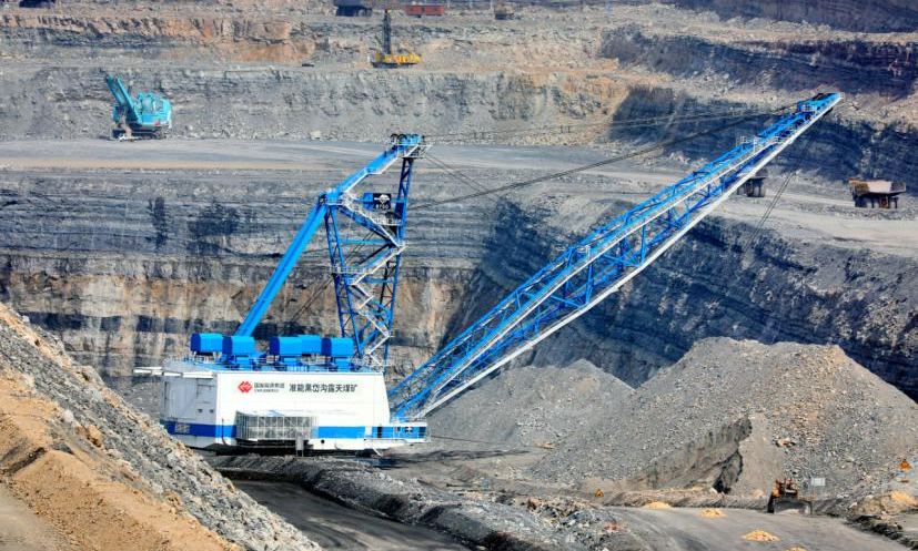 在準(zhǔn)能集團黑岱溝露天煤礦南500米作業(yè)區(qū)內(nèi)，礦山設(shè)備的“巨無霸”——吊斗鏟正在與300噸級礦用無人駕駛卡車協(xié)同作業(yè)。黑岱溝露天煤礦擁有亞洲唯一一臺8750-65吊斗鏟，該設(shè)備自重5307.2噸、作業(yè)半徑100米、斗容90立方米。崔龍 攝
