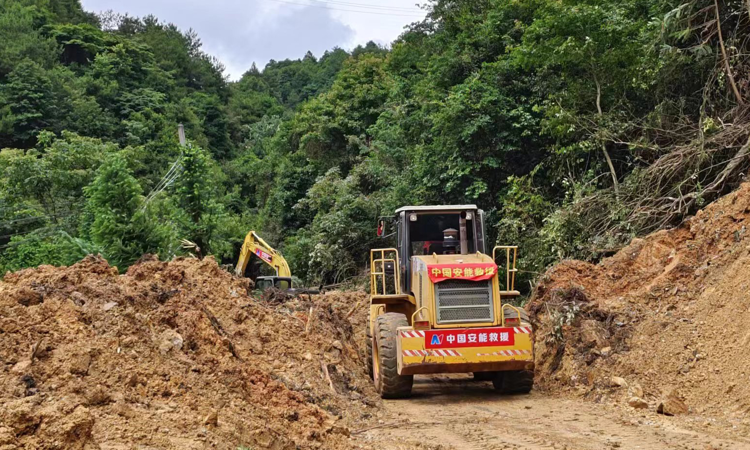 6月16日，廣東省梅州多地出現(xiàn)大暴雨局部特大暴雨，其中，平遠縣泗水鎮(zhèn)出現(xiàn)道路、通信、供電、供水中斷情況，多處發(fā)生山洪、山體滑坡、人員受困，梅州市已啟動防汛Ⅰ級應(yīng)急響應(yīng)。根據(jù)相關(guān)部門要求，中國安能二局從南昌、廈門、深圳等方向共抽組111人專業(yè)力量、30臺（套）救援裝備，于6月17日20時緊急趕赴災(zāi)區(qū)，主要受領(lǐng)平遠縣上舉鎮(zhèn)S239線、通往平遠縣泗水鎮(zhèn)X038線2個方向道路搶通任務(wù)。圖為X038道路搶通現(xiàn)場。