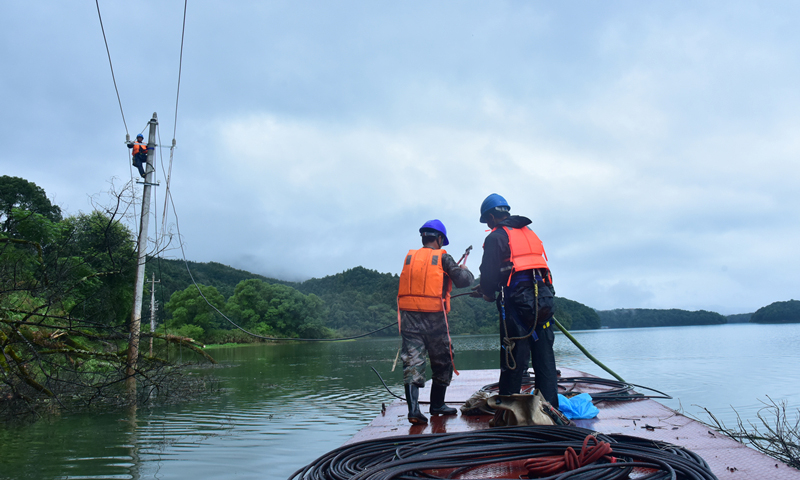 國家電網江西吉安供電公司工作人員在10千伏利田線對暴雨后被大樹壓斷的支線進行搶修。