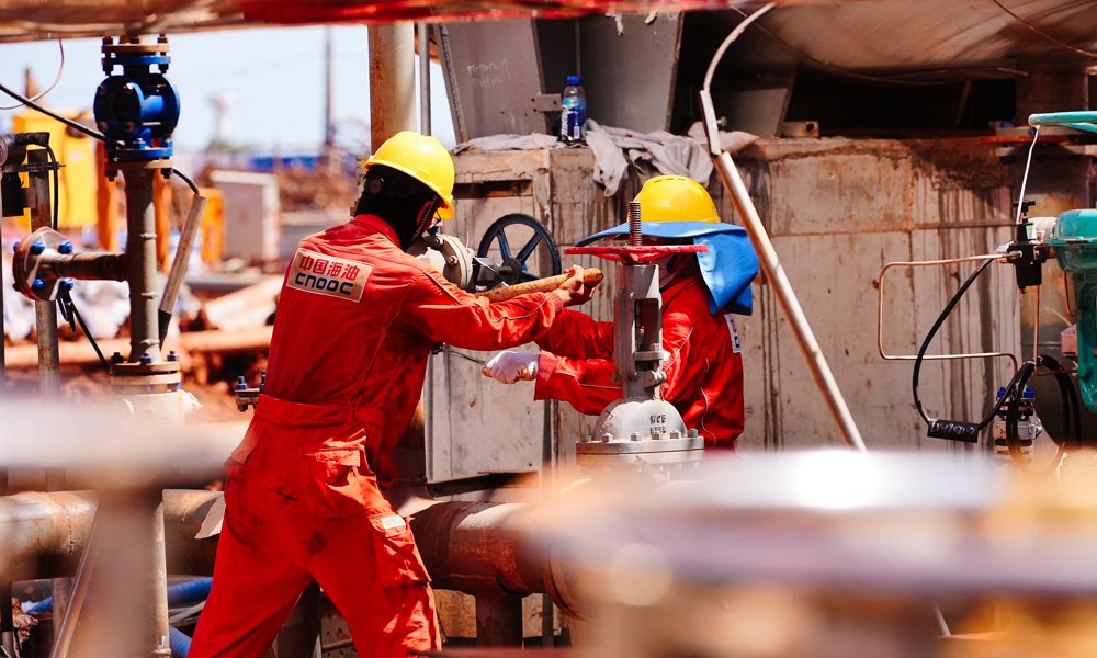 在海上，千人劈波斬浪施工忙。今年3月先后完成兩個平臺的安裝，隨后爭分奪秒鉆井——鉆井人員優(yōu)化井身結(jié)構(gòu)、研用高性能環(huán)保鉆井液，破解了斷塊地層鉆進易坍塌、致密薄儲層難鉆遇的難題。今年5月，首批6口井完鉆，較計劃提前40天。同時，海上配備的固定式圍油欄筑牢安全環(huán)保堅實防線。圖為現(xiàn)場施工人員在安裝閥門。