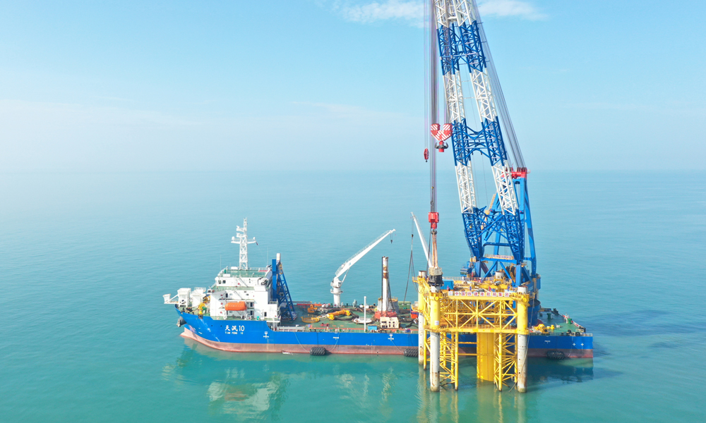 目前，由中國鐵建港航局承建的申能海南CZ2海上風(fēng)電示范項目正全力推進風(fēng)機基礎(chǔ)施工，建設(shè)團隊將于11月完成全部風(fēng)機基礎(chǔ)施工。該項目全容量投產(chǎn)后每年可為電網(wǎng)提供清潔電能38.2億千瓦時、節(jié)約標煤115萬噸，減少排放氮氧化物約1.4萬噸、二氧化碳約299萬噸，對加速實現(xiàn)國家“十四五”現(xiàn)代能源體系建設(shè)規(guī)劃，服務(wù)海南自貿(mào)港和“清潔能源島”建設(shè)具有重要意義。圖為海上施工作業(yè)現(xiàn)場。