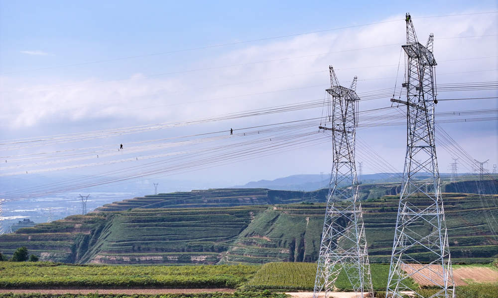 國家電網(wǎng)甘肅送變電公司施工人員在750千伏隴東換流站接入工程跨越330千伏崆塬Ⅰ線工程現(xiàn)場架設(shè)導(dǎo)線。