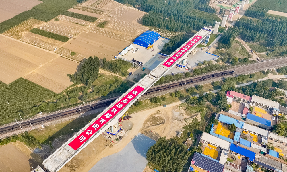 此次轉(zhuǎn)體施工鐵路“天窗”時(shí)間僅為60分鐘。為確保鐵路運(yùn)營安全，項(xiàng)目建設(shè)團(tuán)隊(duì)全面梳理關(guān)鍵工序，嚴(yán)格落實(shí)技術(shù)交底，并在正式轉(zhuǎn)體前進(jìn)行了試轉(zhuǎn)，確保整套轉(zhuǎn)體系統(tǒng)可靠運(yùn)行。轉(zhuǎn)體過程中，項(xiàng)目建設(shè)團(tuán)隊(duì)采用北斗衛(wèi)星轉(zhuǎn)體系統(tǒng)監(jiān)測，實(shí)時(shí)感知當(dāng)前轉(zhuǎn)體橋姿態(tài)，通過“全程可視化、控制智能化”提前分析預(yù)警，保障整個(gè)轉(zhuǎn)體過程安全可控。圖為任丘特大橋跨京九鐵路轉(zhuǎn)體橋轉(zhuǎn)體完成后航拍。