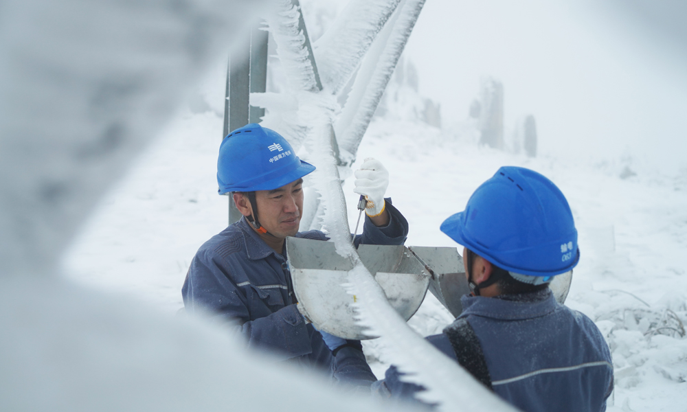 在牛從甲牛側接地極線路210號塔，南方電網超高壓公司曲靖局運維人員開展模擬導線覆冰厚度測量。