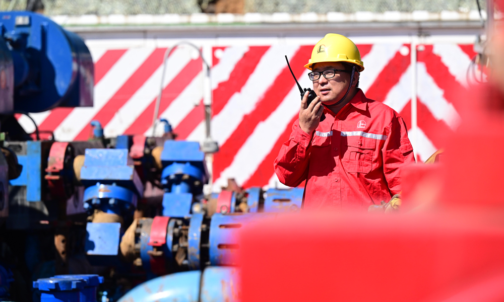 技術(shù)人員在全電動泵儲層改造現(xiàn)場指揮員工保養(yǎng)設(shè)備。