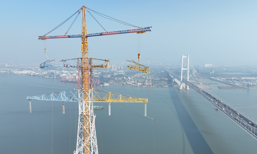 近日，在500千伏沙廣甲乙線改造工程現(xiàn)場，施工人員對(duì)跨江鐵塔進(jìn)行改造施工。