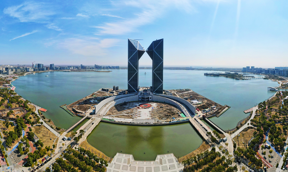 近日，位于中國（上海）自由貿易試驗區臨港新片區，由中國建筑旗下中建二局華東公司承建的臨港西島中銀金融中心項目建設取得新進展，項目外立面幕墻施工進入收尾階段，滴水湖畔“雙子塔”，臨港第一高地標雄姿初現。圖為空中俯瞰位于臨港新片區滴水湖畔的中銀金融中心大樓。