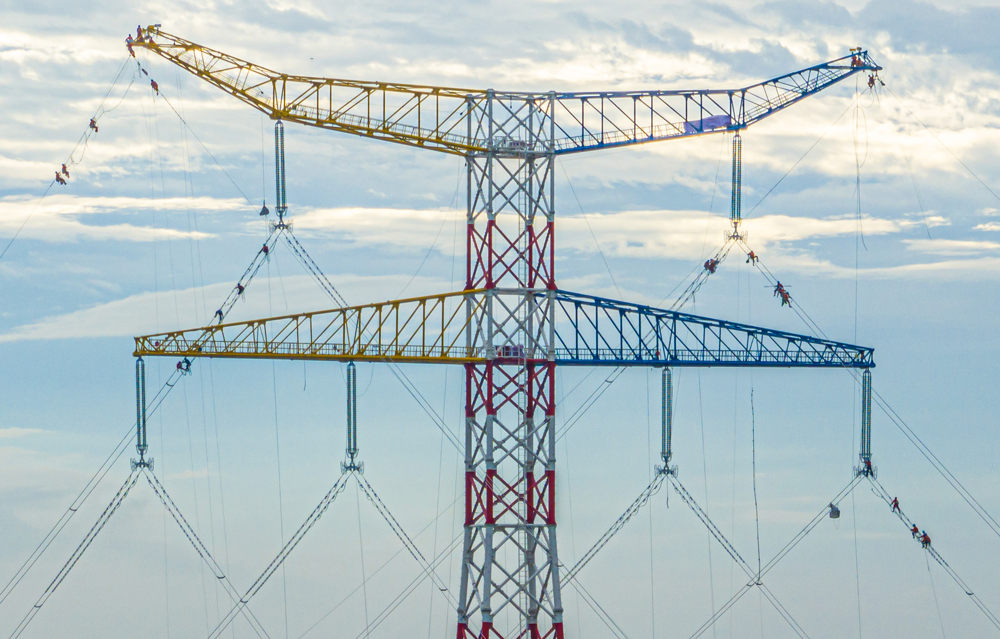 圖為獅南甲乙線獅子洋大跨越新鐵塔，塔高264.5米刷新國內水上輸電鐵塔新紀錄，施工人員在進行線路附件安裝，該工程改造后可提升線路輸電容量40%。