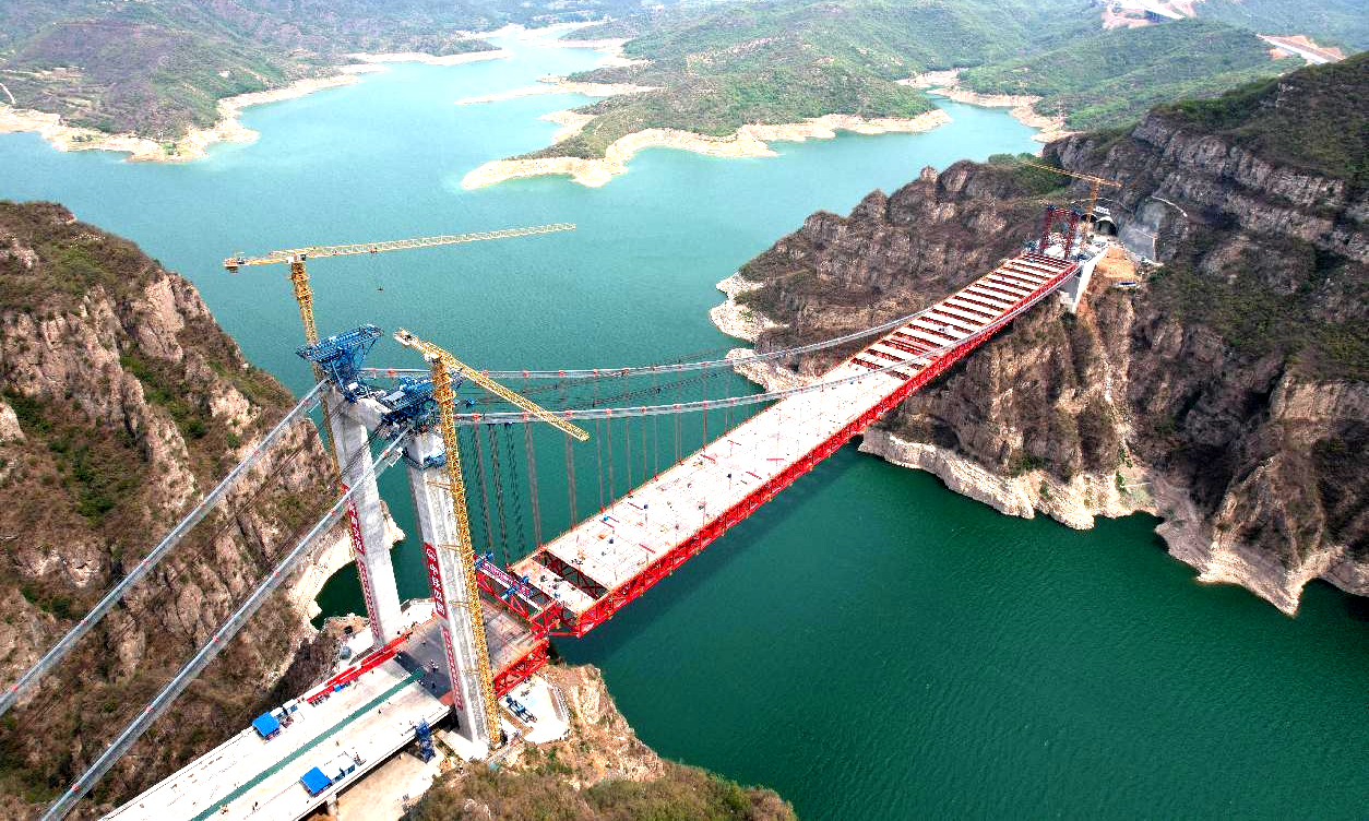 近日，中國中鐵旗下中鐵四局承建的世界首座獨(dú)塔單跨地錨式回轉(zhuǎn)纜懸索橋——濟(jì)新黃河大橋鋼桁梁全部吊裝完成。