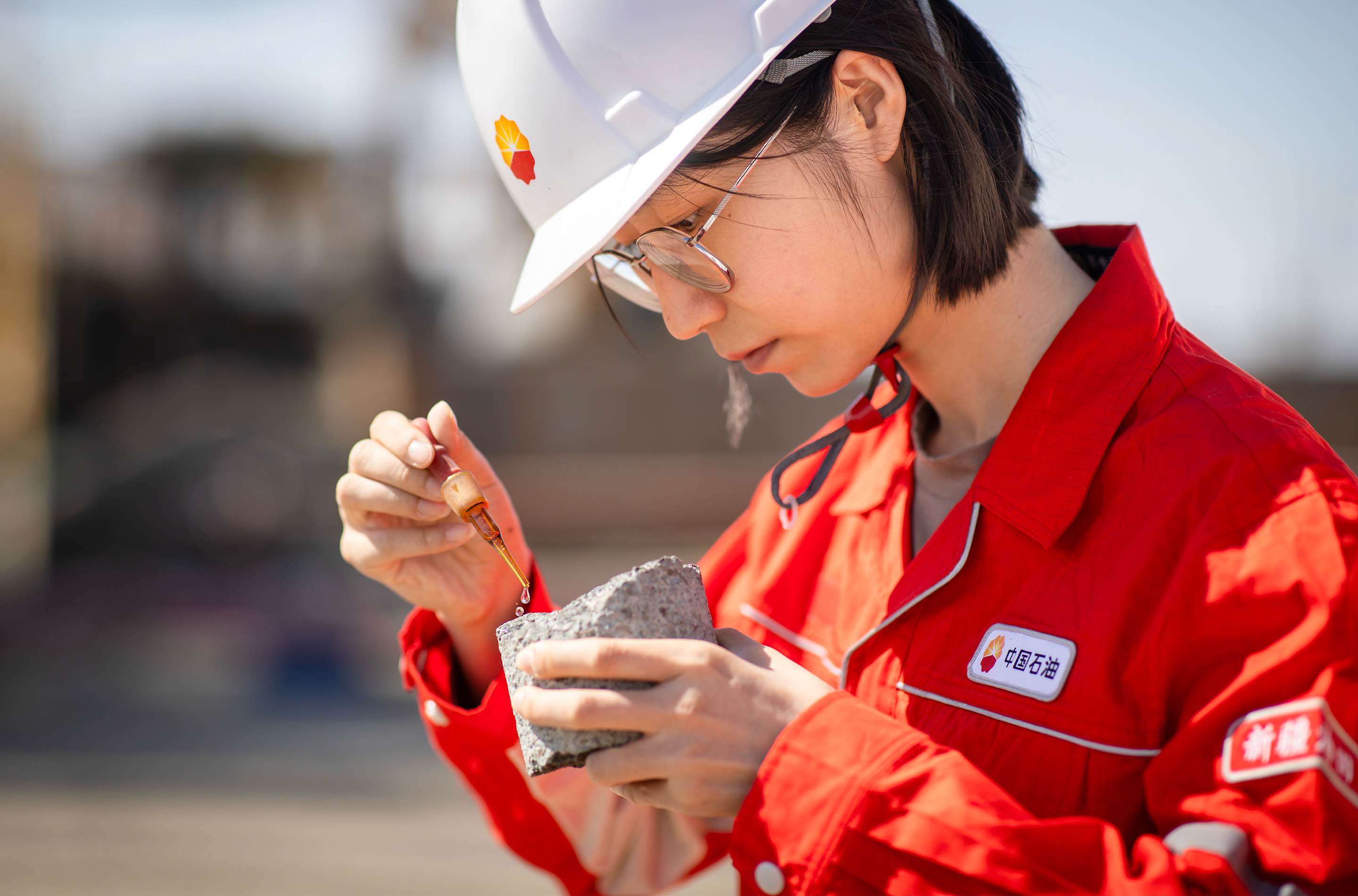 在新疆油田八區的一口開發井鉆井現場，勘探開發研究院稀油開發研究所的科研人員小心翼翼地將稀鹽酸輕輕點在巖芯表面，仔細觀察巖芯的含油性。這塊散發著油香的巖芯，承載著老區“壓艙石”工程的關鍵數據。作為新疆油田2025年為老區“壓艙石”工程部署的55口開發井之一，這口井的密閉取芯工作剛剛結束，科研團隊駐守現場。他們緊緊跟蹤巖芯出筒的每一個環節，圍繞巖芯的飽和度等關鍵指標，緊鑼密鼓地開展相關試驗，以嚴謹執著的態度精準“破譯”油藏的奧秘。